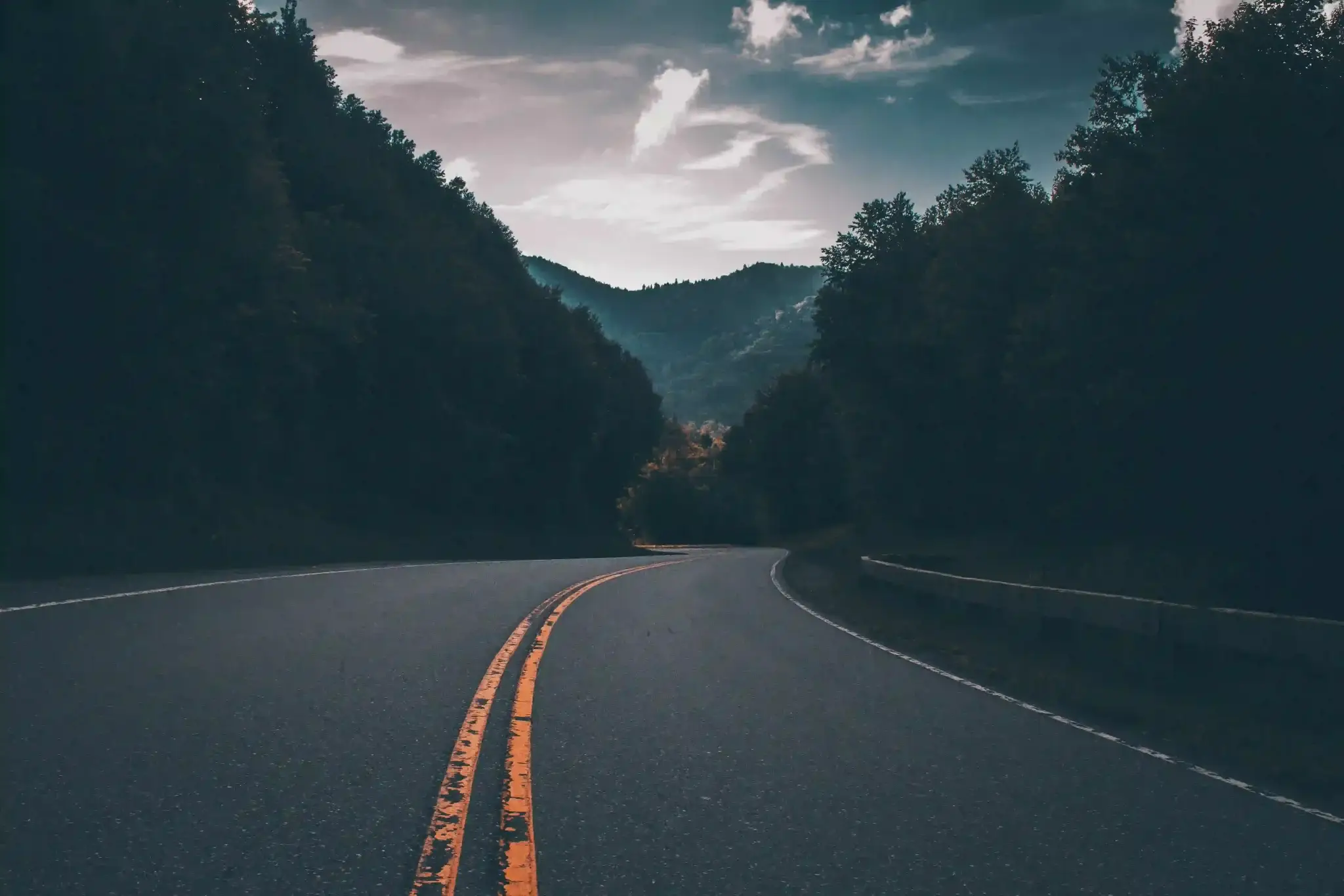 Balneário Piçarras, em Santa Catarina: imagem de uma estrada rodeada de floresta a noite, com montanhas ao fundo