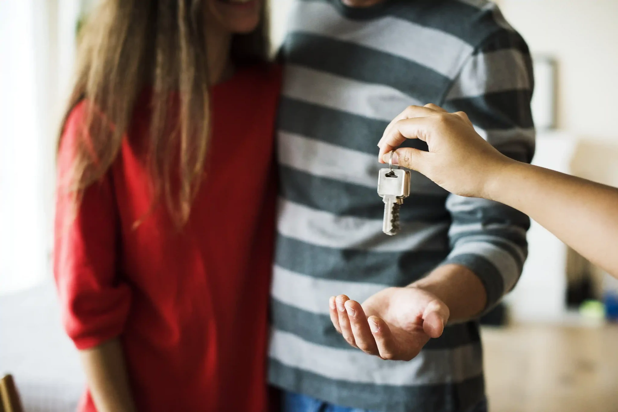 Começar o ano com uma casa nova: casal recebendo as chaves do seu imóvel
