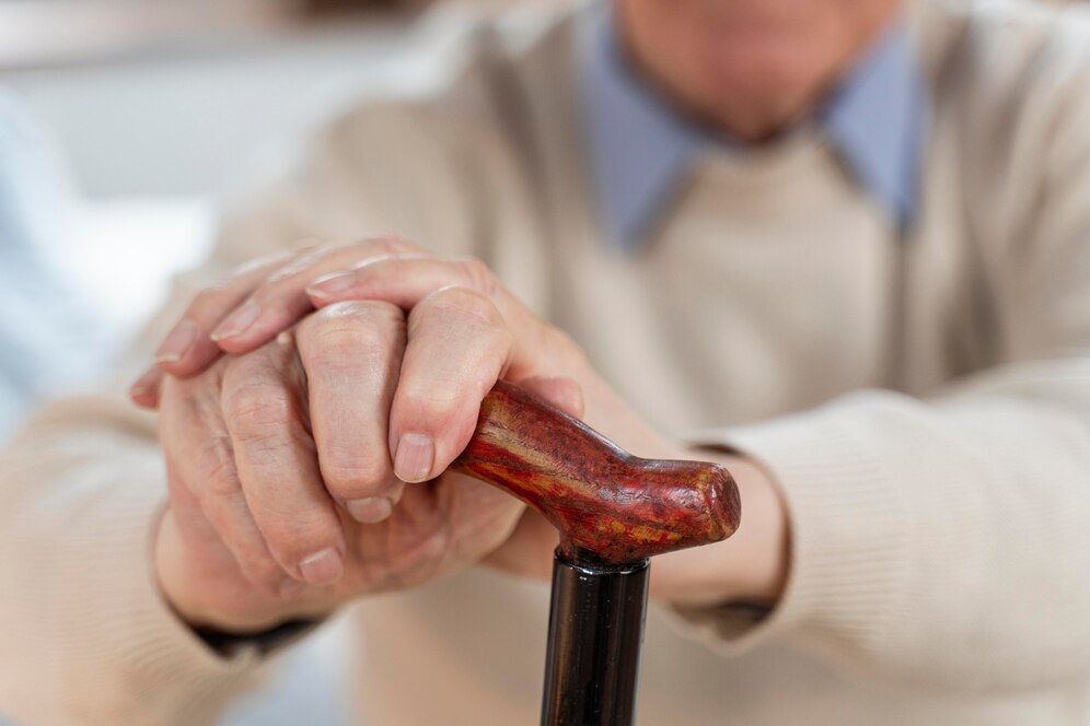 Abandono de Incapaz em condomínio: pessoa idosa segurando bengala com duas mãos