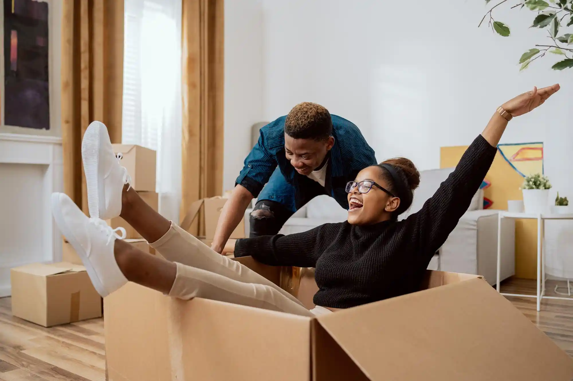 Apartamento mobiliado para alugar: casal se divertindo com as caixas da casa nova.