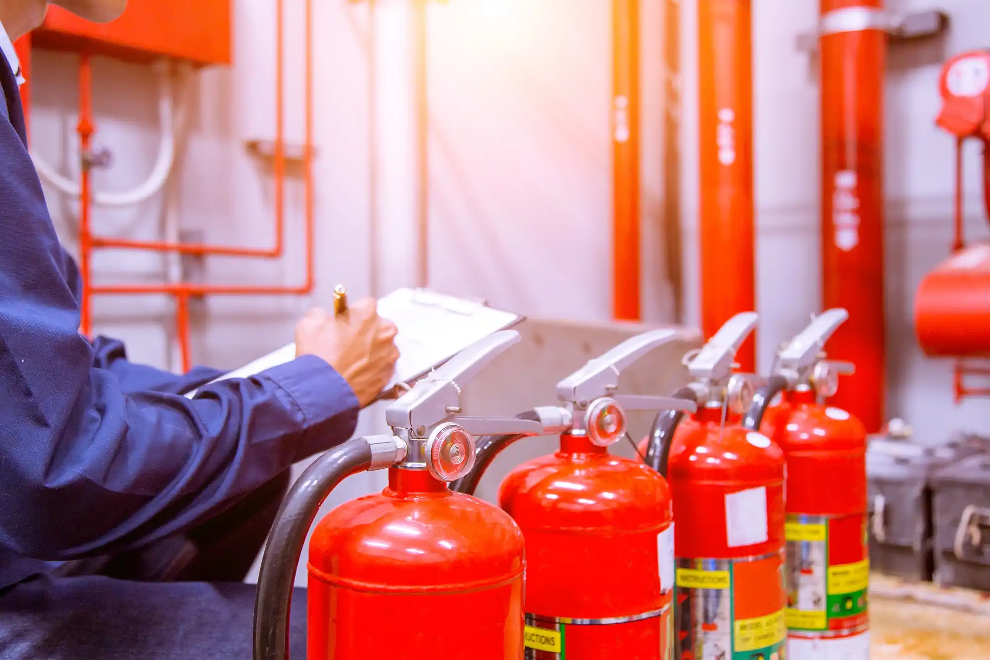 Auto de Vistoria do Corpo de Bombeiros (AVCB): pessoa vistoriando diversos extintores de incêndio