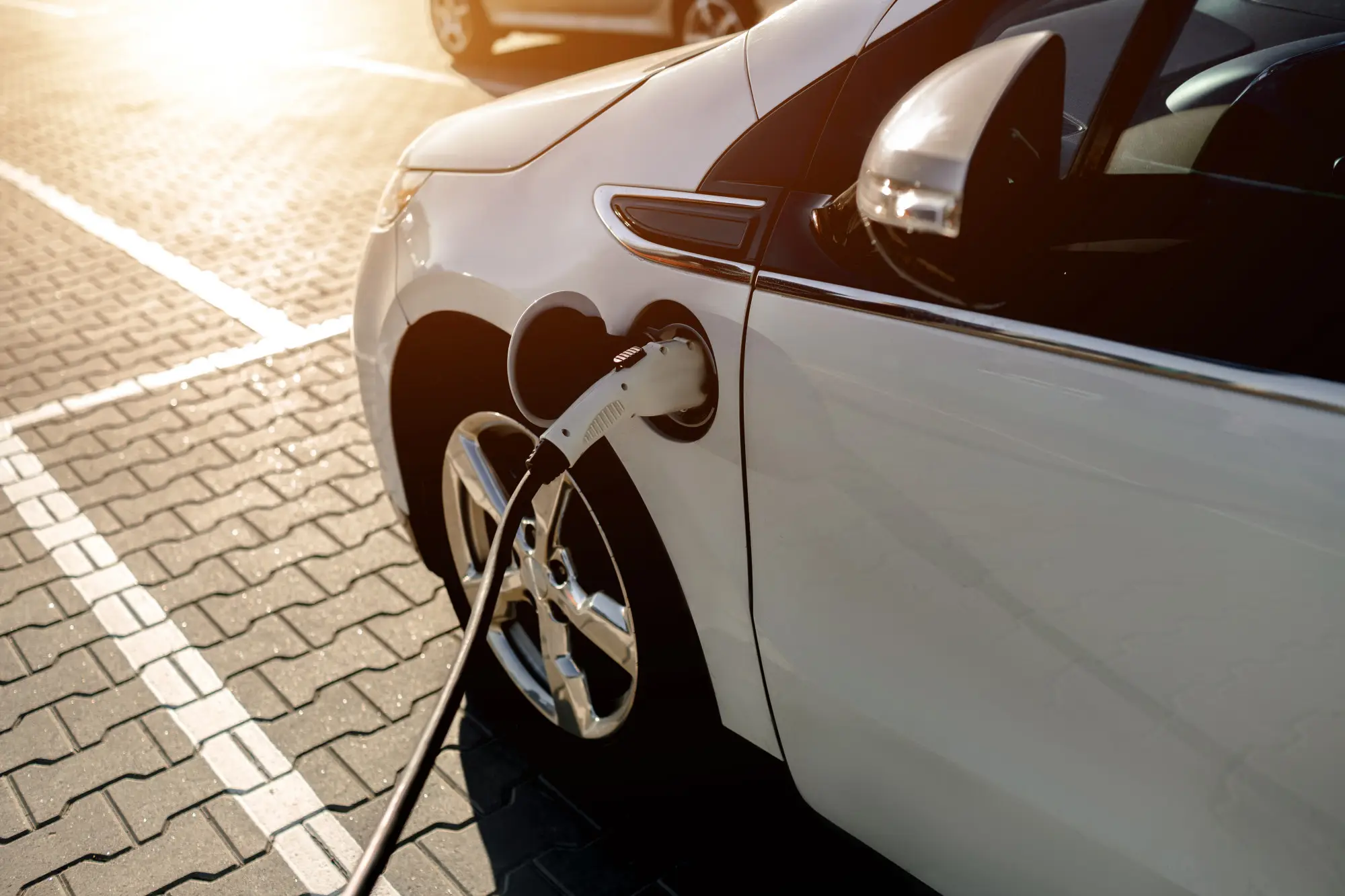 Carros elétricos em condomínio: carro estacionado em vaga enquanto faz recarga.