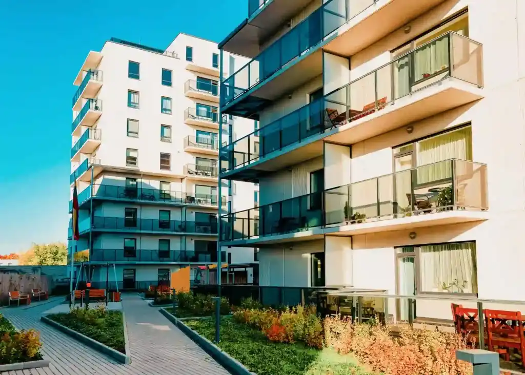 Casa ou apartamento: imagem de dois prédios de condomínio com plantas na área externa