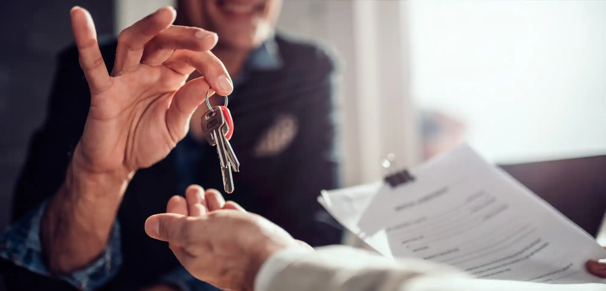 Como consultar FGTS e dicas para uso na compra de imóvel: pessoa entregando chave de uma casa para pessoa com contrato