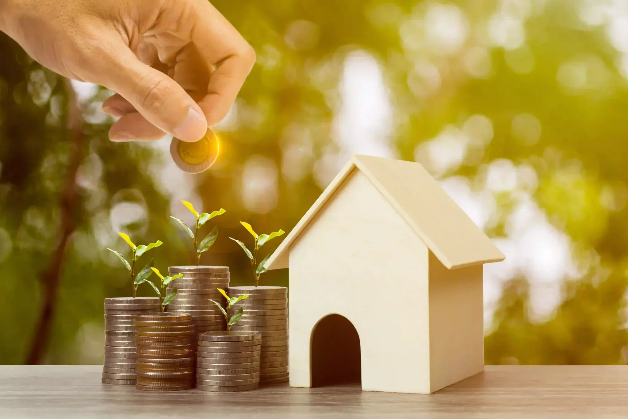 Comprar imóvel para investir: miniatura de casa perto de moedas empilhadas