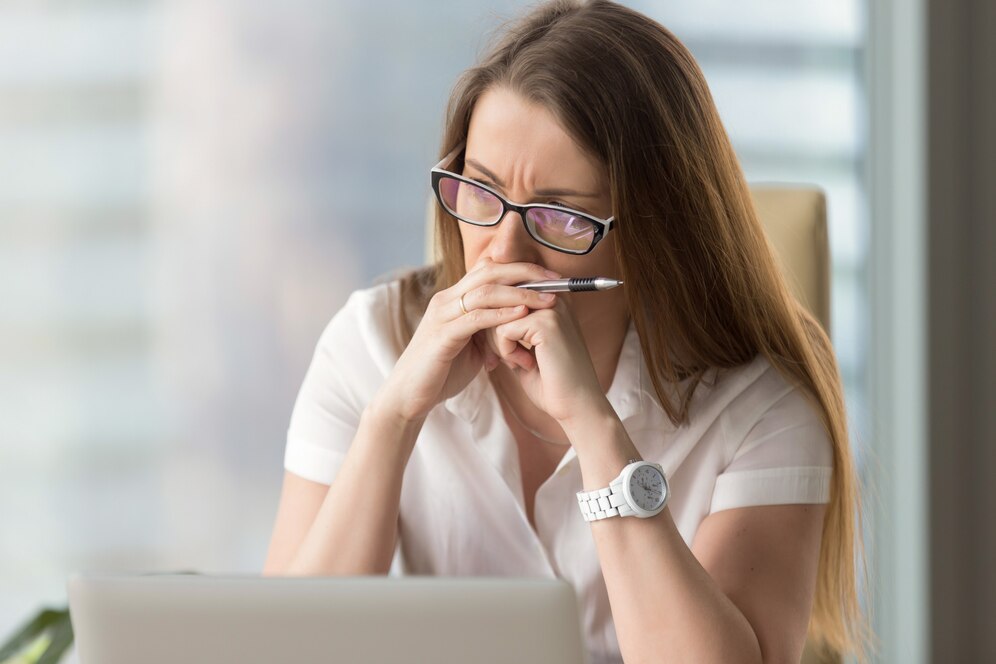 Direitos do condômino inadimplente: mulher olhando para o notebook de forma preocupada