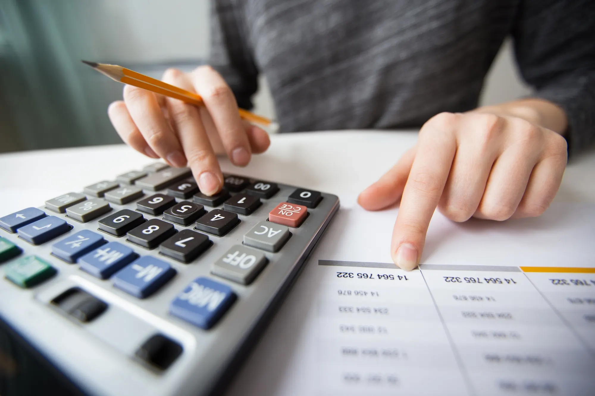 Conselho fiscal de condomínio - Mãos analisando dados numéricos e utilizando uma calculadora