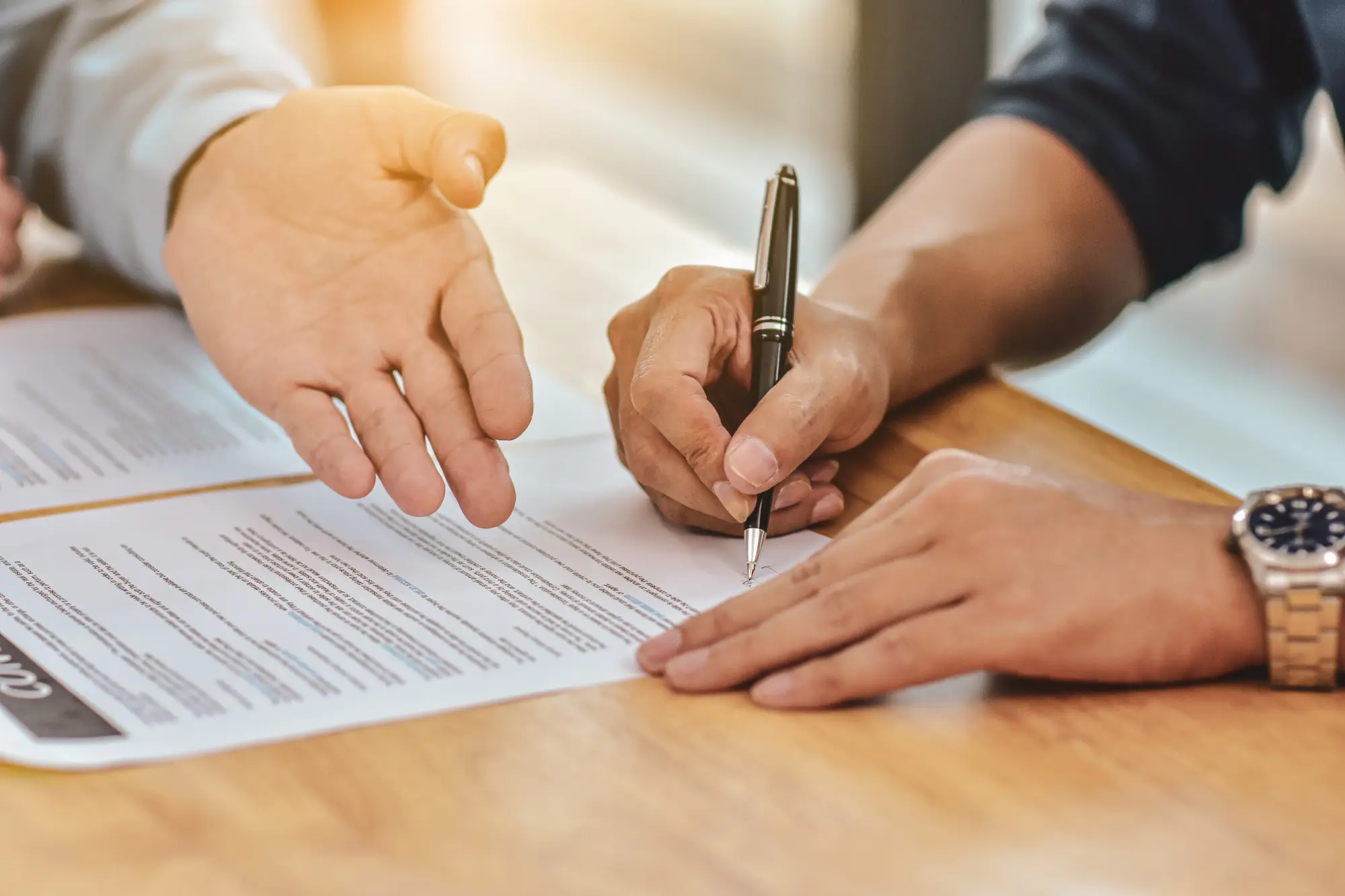 Financiamento imobiliário: como solicitar para comprar sua casa: pessoas assinando contrato em uma mesa