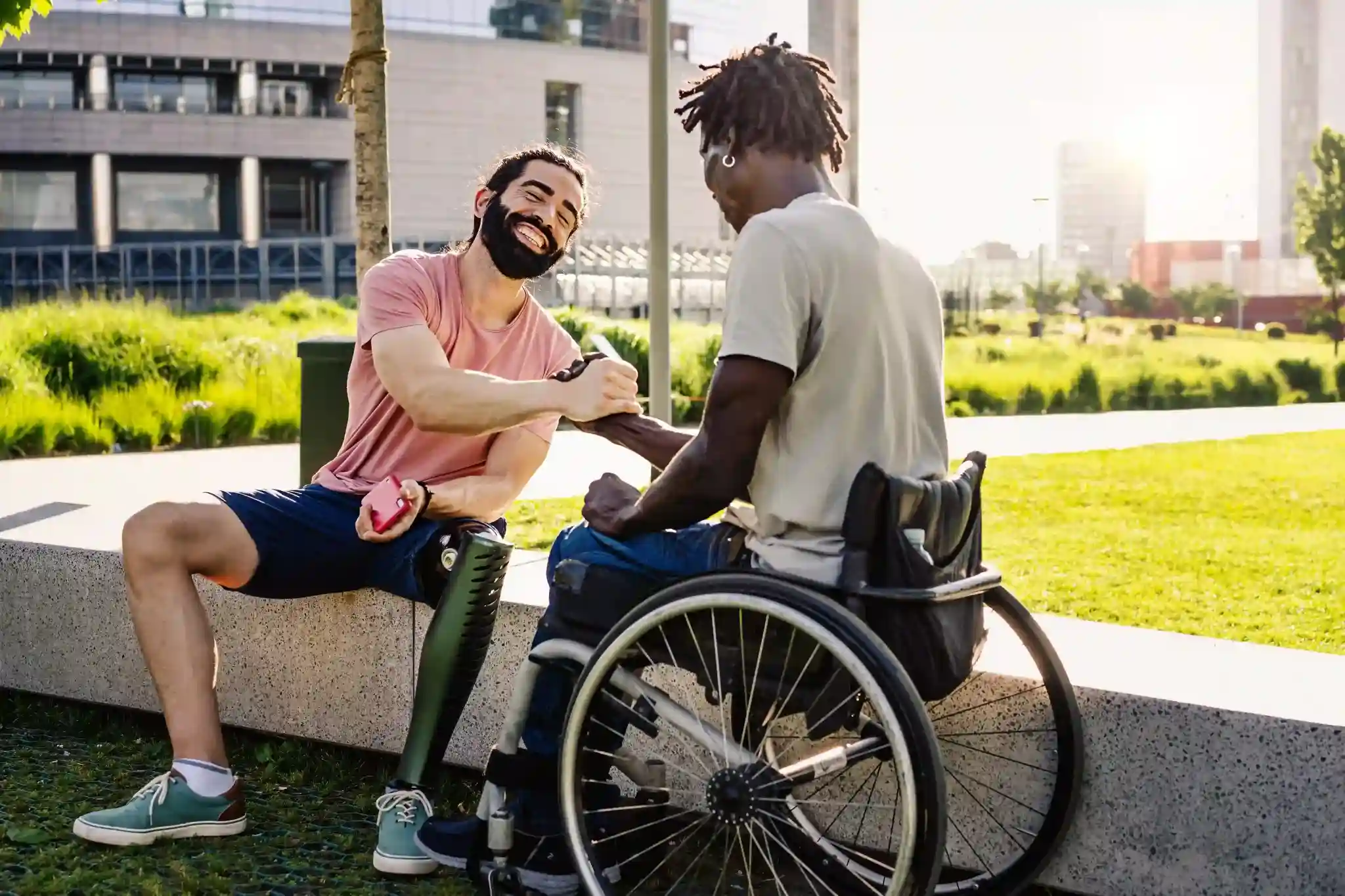 Imóveis com acessibilidade: dois homens com deficiência conversando e apertando as mãos
