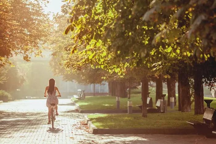 Independência, em Porto Alegre: pessoa pedalando no parque com árvores em volta e luz do sol.
