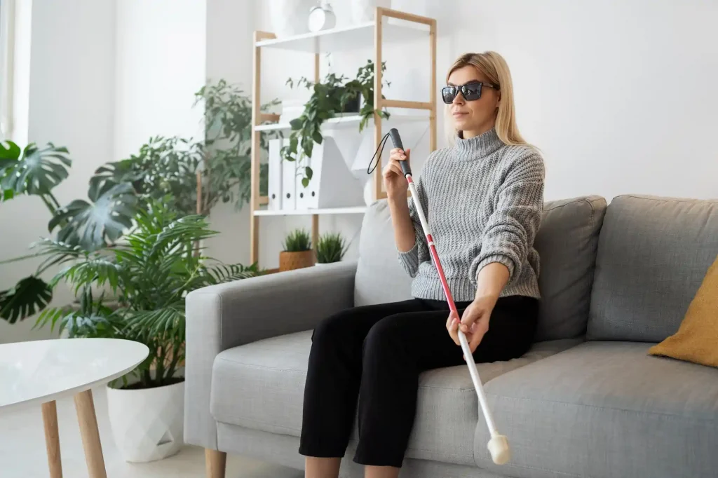 Lei da acessibilidade: mulher com deficiência visual sentada no sofá de casa