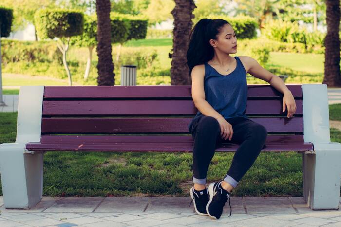 Moinhos de Vento: mulher sentada em banco roxo de parque.