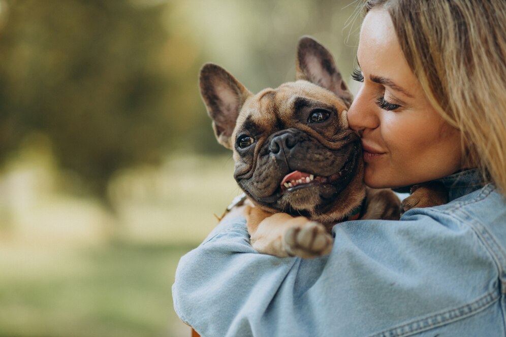 Plano de Saúde pet: mulher abraçando seu cachorro enquanto dá um beijo nele