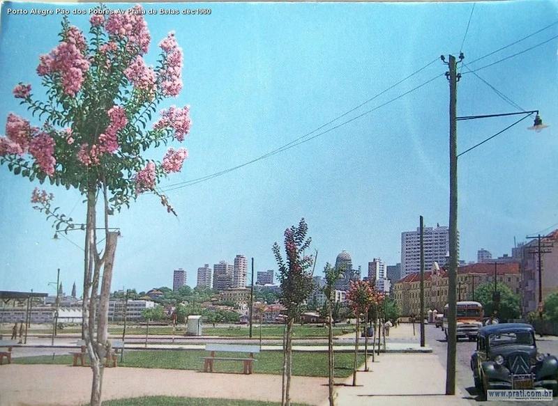 Praia de Belas, Porto Alegre em 1960: parque com flores, carros, árvores, prédios e luz do dia. 