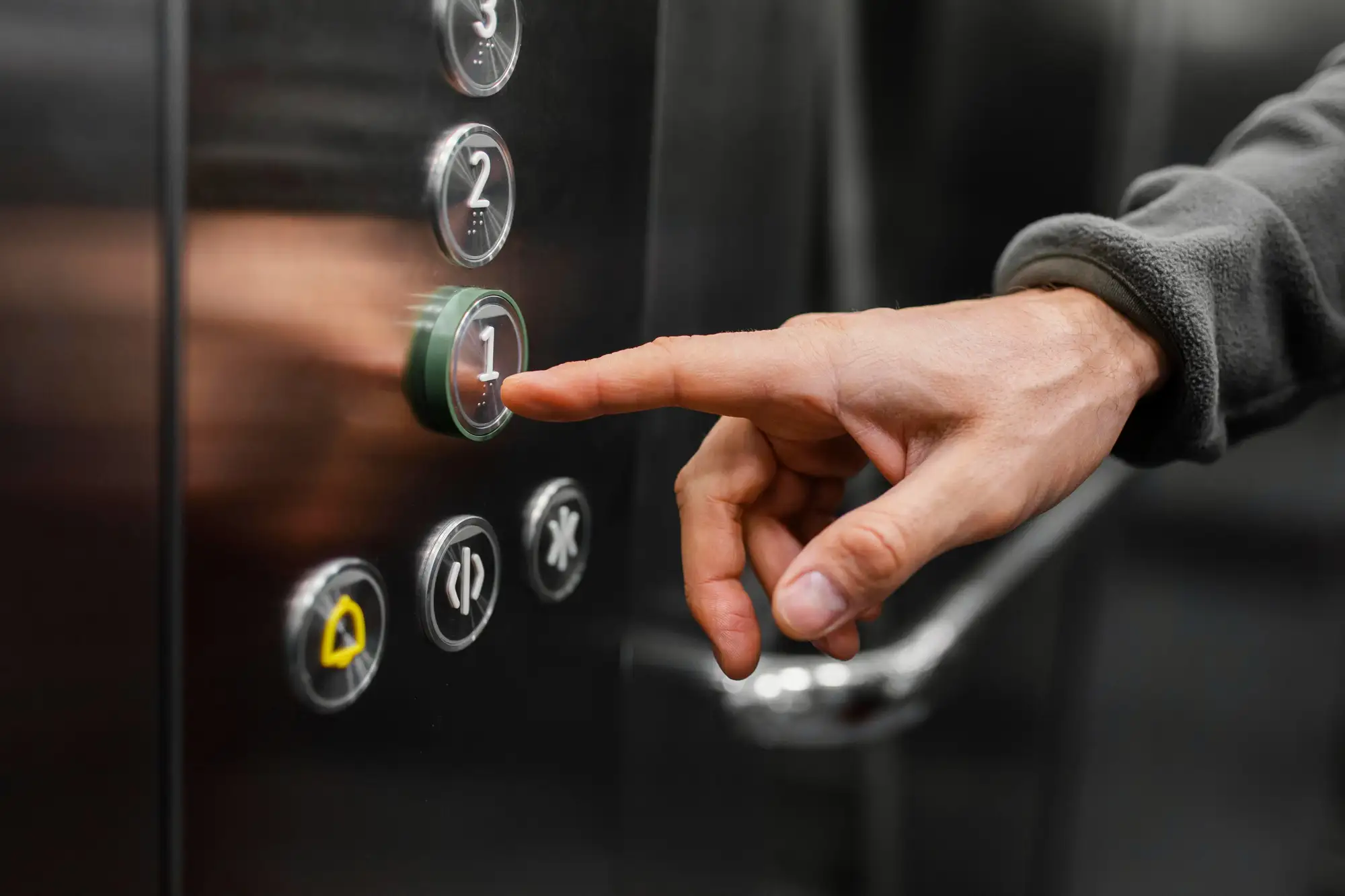 Renúncia de síndico: pessoa apertando o botão do primeiro andar do elevador