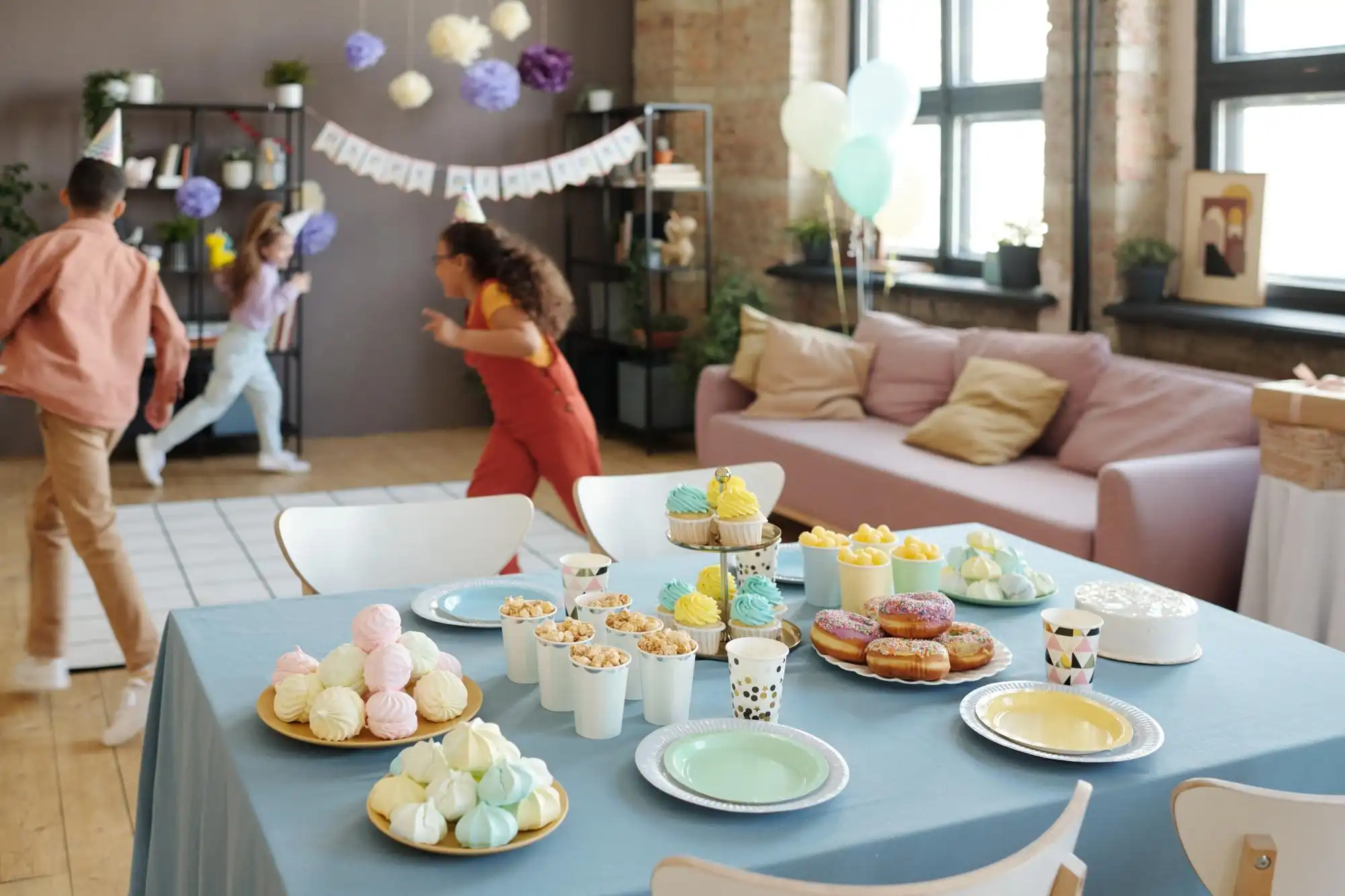 Regras do Salão de Festa em Condomínio: crianças brincando atrás de uma mesa de doces. 