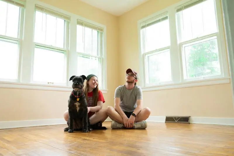 Santo Antônio: imagem de casal com um cachorro olhando para a casa dem móveis