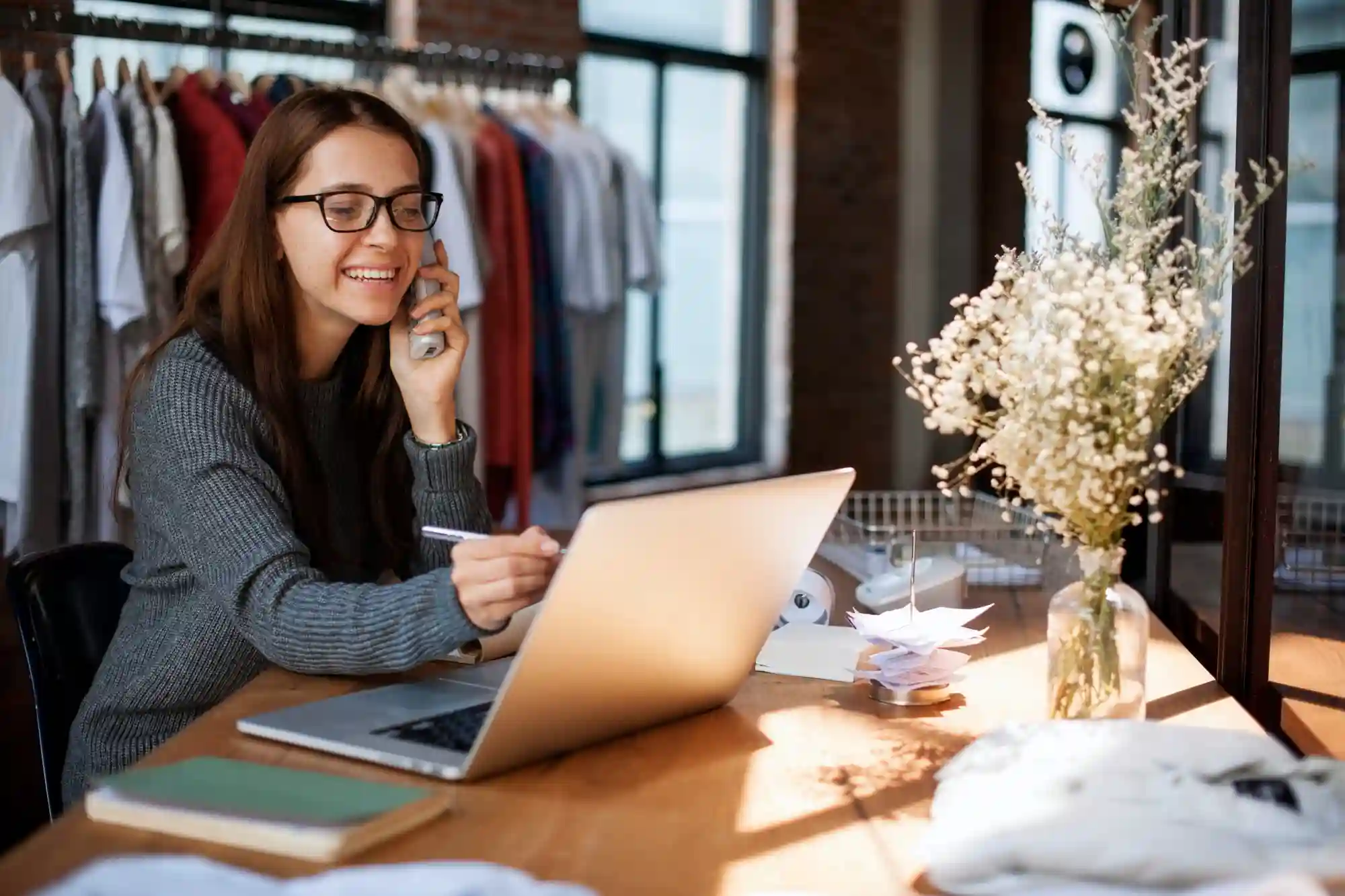 5 tipos de imóveis comerciais para escolher: pessoa em uma mesa com notebook, livros, papeis e abajur